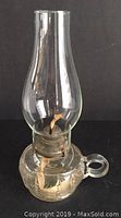 Full 11-inch oil lamp with clear glass reservoir and chimney, metal burner assembly and wick.