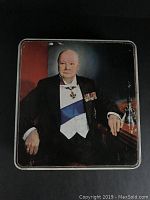 Top view of rectangular metal tin showing color portrait of Winston Churchill in formal attire on lid.