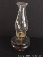 Full view of complete clear glass oil lamp showing chimney and base