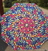 Top view of colorful 7 foot diameter beach umbrella showing vibrant graffiti-style multicolor pattern and wind vent