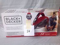 Boxed Black & Decker Cordless Lithium Hand Vacuum in red and black, model HVA320JO5, displayed on packaging with a man using the vacuum shown in the image.