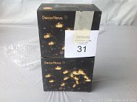 Two stacked unopened boxes of DecorNova string lights showing packaging and branding