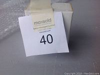 Sealed white box with MaxSold lot sticker number 40 placed on top, showing the unopened product packaging.