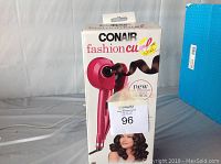 Front view of the open box of the Conair Fashion Curl hair styler showing the product image and branding.
