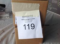 Cardboard box with MaxSold auction label number 119 attached on the front
