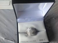 Sterling silver ring size 7 with multiple rows of clear stones inside a jewelry box with 'Sterling Silver' and 'Size 7' labels.