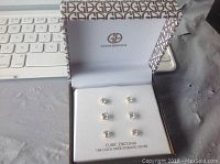 Three pairs of cubic zirconia stud earrings set inside branded Gianni Bernini box, with box lid open showing logo and text indication of 18K gold over sterling silver.