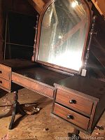 Front angled view of antique wooden dresser with arched mirror and four drawers, showing some drawer opened and wood grain details