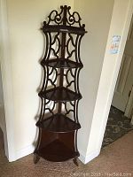 Full view of the wooden corner trinket shelf showing its five tiers and dark wood finish.
