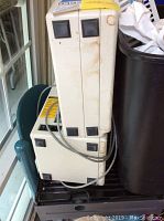 Unimark Sprite airline ticket printer stacked vertically with visible wear and discoloration on its surface, showing front and side views.