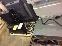 Photo of three backup batteries including two black APC units and one large gray XPower PowerSource 400 unit, showing cables and power outlets.