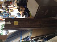 Full view of vintage wooden wall-mounted box for roll down maps, showing length and wood texture.