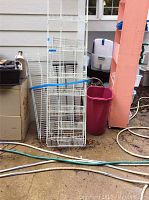 White wire shelves of varying sizes leaning against house exterior