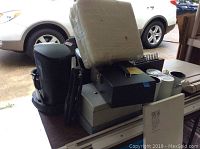 Photo showing three metal cash drawers stacked on table and wrapped new rug pad placed on top