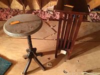 Photo showing both occasional tables on attic floor, highlighting the round table with stone top and square pinewood table with slatted sides.