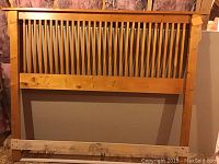 Wooden headboard with vertical slats and natural wood finish.
