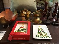 Set of brass, wooden candle holders, brass Mexican bowl, brass wall shelves and Crate and Barrel holiday plates