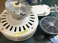 White Hunter ceiling fan motor housing with open wiring and part of fan blades visible.