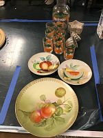 Overview photo of jello molds, orange juice pitcher, 7 glasses, and 3 decorative plates with fruit designs.