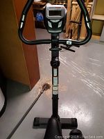 Front view of the HealthRider stationary bike showcasing the handlebar with integrated grip sensors and digital display monitor.