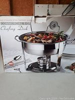 Photo of the chafing dish box with image showing filled dish and components including fuel holder and lid.