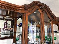 Wide shot of glassware cabinet showing multiple colored sets including the purple decanter and glasses