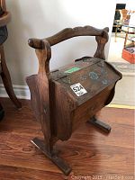 Left front view of wooden sewing basket showing handle and floral painted lid.