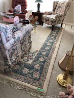 Living room view showing rug under sofa, armchairs, and coffee table, displaying overall design and condition.