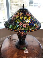 Full view of lamp on wooden table near window