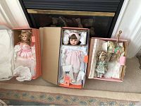 Three King State Design Debut dolls in original orange and beige boxes, including two larger dolls in pink dresses and one smaller doll in floral dress with bonnet