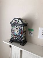 Front view of 10.5 inch tall Tiffany style table clock with stained glass floral and bird design.