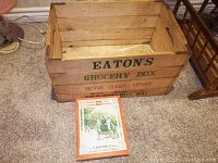 Wooden Eaton's grocery box with the vintage 1901 Eaton's catalog placed in front on carpeted floor.