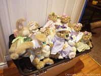 Photo showing 11 Bearrington Collection stuffed animals in pastel dresses, hats, and bows, including bears, a duck and rabbits.