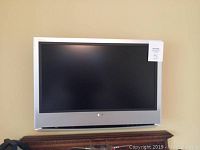 Sony flat screen television mounted on wall, silver bezel, black screen, size approx 32 inches
