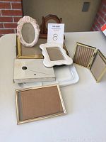 Eight assorted picture frames on white table showing variety of materials and shapes