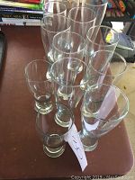 Top view showing all 12 beer glasses arranged closely with 2 short glasses visible in front and 10 tall glasses behind.