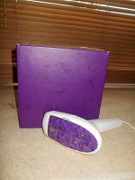 White handheld laser hair remover device with purple treatment window and purple box with Silk'n logo