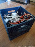 Black plastic crate containing assorted electrical cords and two white timer devices