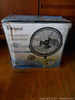 Box front showing Whirlpool branding and image of the 18-inch air circulator fan with some wear on the box.