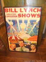 Frontal view of framed Bill Lynch Greater Exposition Shows vintage circus poster showing carnival rides and three people in foreground.