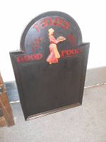 Full view of the black wooden chalkboard menu sign with 'Today's Good Food' text and vintage cook illustration at the center.