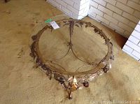 Top view of the round glass coffee table with metal floral details beneath the glass.