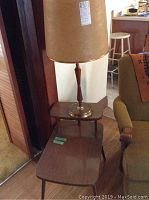 End table with wooden finish and lamp on top, showing size and style