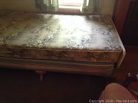 Top view of mattress showing floral patterned fabric and rolled handles on side.