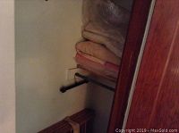 Blankets folded and stacked on shelf inside closet corner
