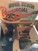 Large Nova Scotia Provincial Exhibition print positioned behind other items, showing vintage style lettering and exhibition imagery