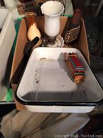 Box with white scalloped glass lamp, brown and tan vases, wooden toy train inside enamel tray