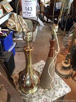 Two Mid-Century Modern table lamps placed on a patterned surface, showing overall height and condition.
