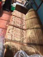 Side angle view showing three floral pattern cushions and velvet upholstery on sofa in a covered wagon environment
