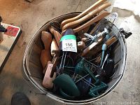 Full view of basket showing various wooden and plastic shoe trees and clothes hangers.